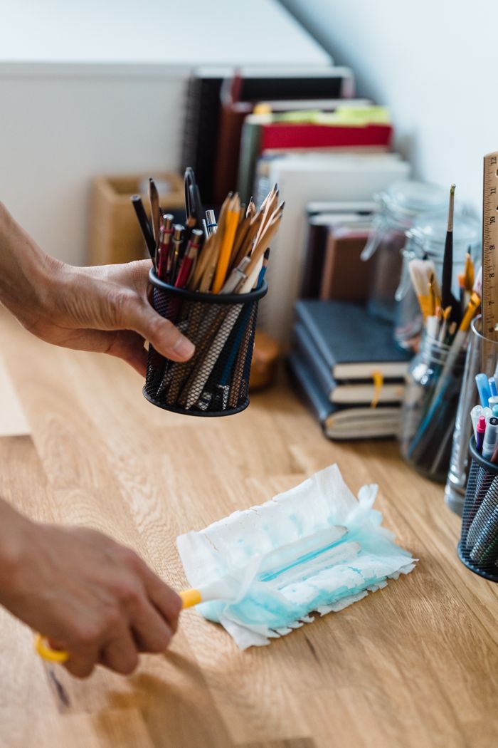 Un bureau propre et bien ordonné, avec de la papeterie et des produits de dépoussiérage pour un espace de travail efficace.